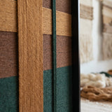 Extreme close-up of Emerald Fables SQ102 showing dense forest green and mustard yarn texture in a black frame.