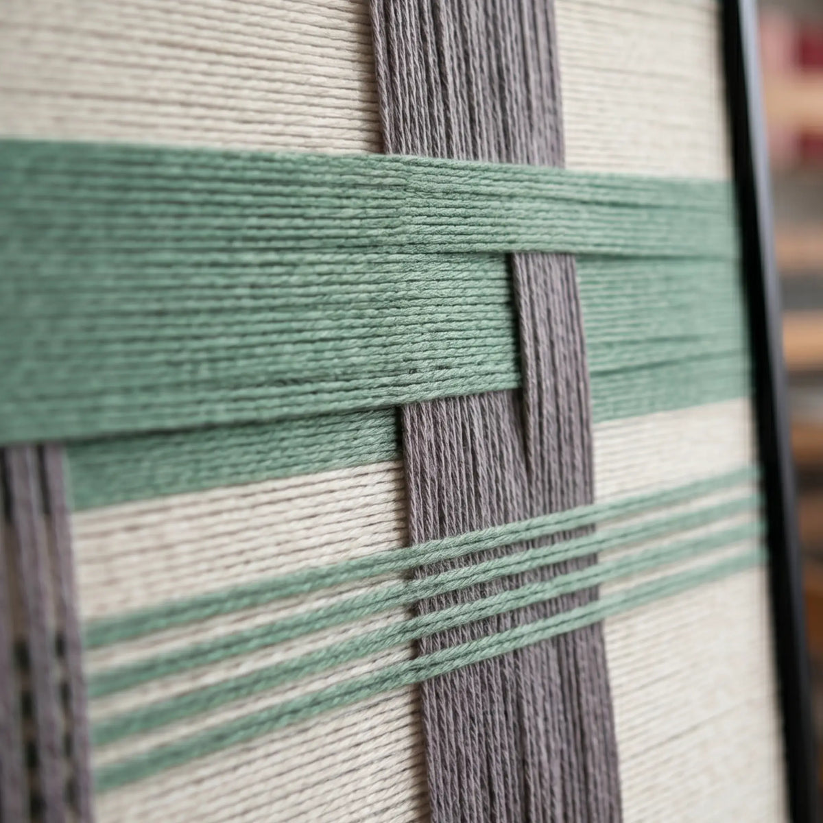Macro view of Muted Spring SQ115 showing raised sage green yarn over gray and cream vertical bands.