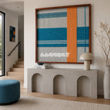 Breeze of Capri SQ117 framed yarn wall art featuring bold orange and blue bands with refined linear accents.