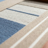 Low-angle close-up of Cerulean Mist SQ130 emphasizing raised blue, beige, white, and taupe yarn texture.