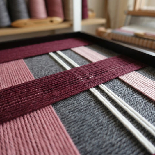 Angled close-up of Merlot Veil SQ133 highlighting textured burgundy, pink, grey, and white hand-wrapped yarn.