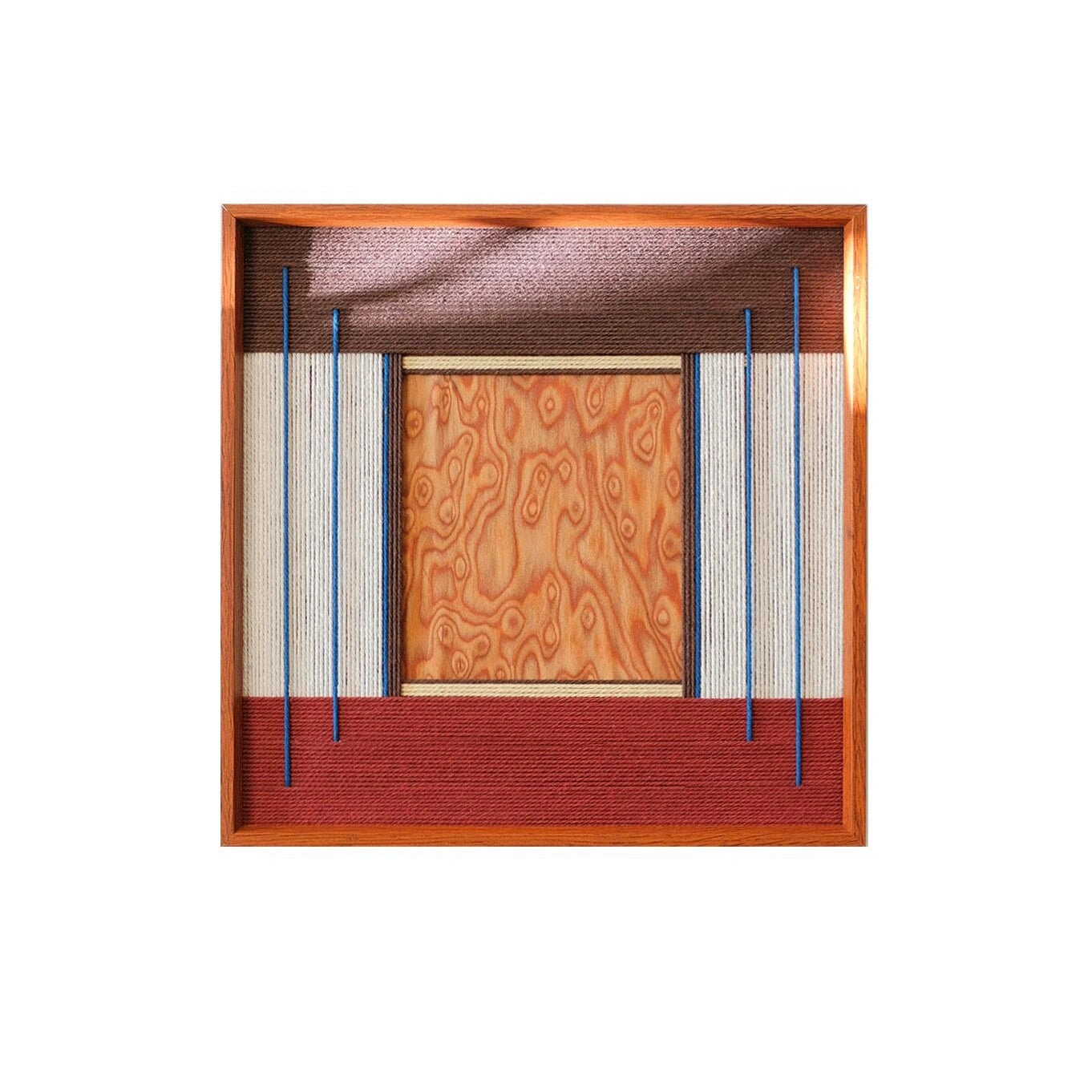 Studio view of a Festive Harmony SQ143 variation with an orange center block framed by blue and white yarn lines.