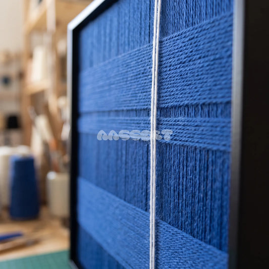 Deep Blue textile art detail: raised blue horizontal bands crossed by a fine white strand.