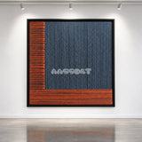 Held Space textile wall art displayed on a gallery wall under spotlights.