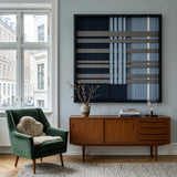 Framed Starry Latitude textile wall art styled elegantly above a wooden sideboard in a sunlit modern living room setting.