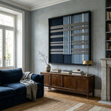 The Starry Latitude hand-woven wool tapestry hangs elegantly above a dark wood sideboard in a cozy living room with blue furniture.