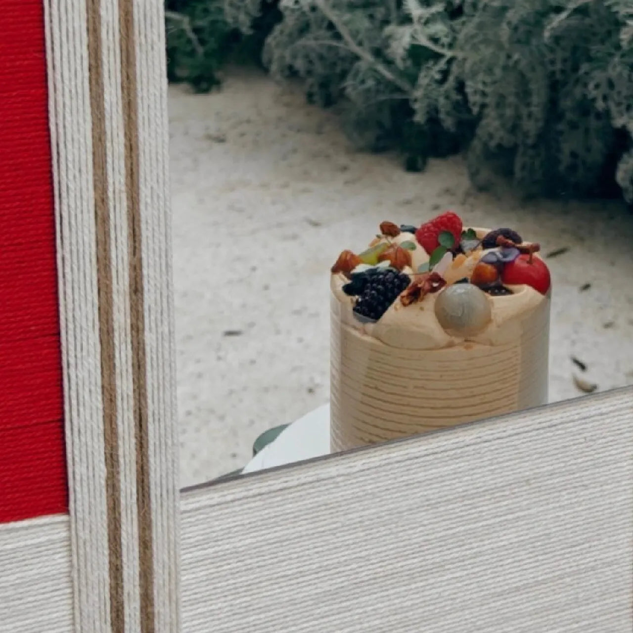Macro shot of The Sun Always Rises mirror art border revealing tight wool stitching and crisp transitions between oatmeal, natural, and red stripe panels.
