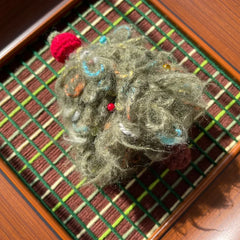 Close-up macro shot of the fluffy wool texture and mixed fibers, revealing the intricate hand-woven craftsmanship of the abstract tree design.