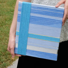 That Summer, the Blue Sea yarn art placed on a nautical rope net, highlighting its coastal-inspired blue gradient pattern
