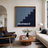 The Eighth Level blue stepped textile wall art displayed above a coffee table in a bright modern conversation living room.