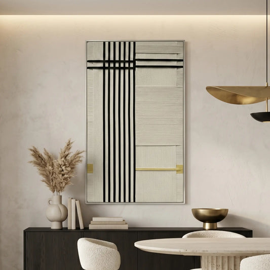 Hand-woven wool wall art with black vertical lines and gold accents hanging above a black sideboard in a modern dining room.