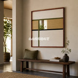 Through the Mirror neutral geometric yarn-framed mirror displayed above a dark wood bench in a calm modern entryway.