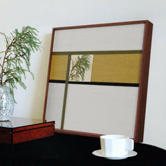 Through the Mirror mirror art displayed next to a teacup on a console, emphasizing clean wool stripe alignment and the crisp reflective panel.
