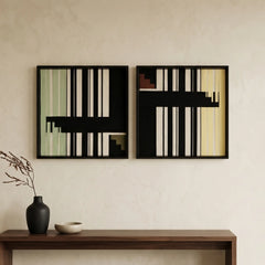 A diptych set of square hand-woven wool wall art in black frames, featuring minimalist black and cream geometric abstract patterns with sage green accents, hanging above a dark wood console.