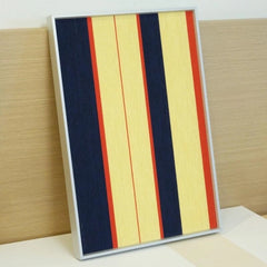 Angled view of Twilight Rush yarn wall art on concrete, showcasing its precise vertical stripe pattern and looped wool texture.
