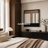 Undisturbed Snow cream taupe and black textile wall art displayed above a dark cabinet in a warm neutral bedroom.