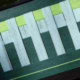 Macro shot of Velvet Vine yarn wall art emphasizing tight stitching and color depth of green and white yarns
