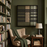 Verdant Silence framed wall art displayed in a cozy library corner above a reading chair next to a dark wood bookshelf.