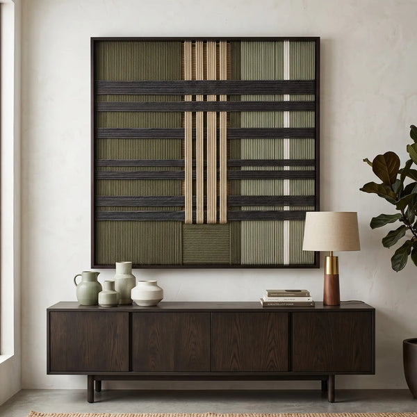 Framed Verdant Silence textile wall art styled elegantly above a dark wood sideboard in a sunlit modern living room setting.