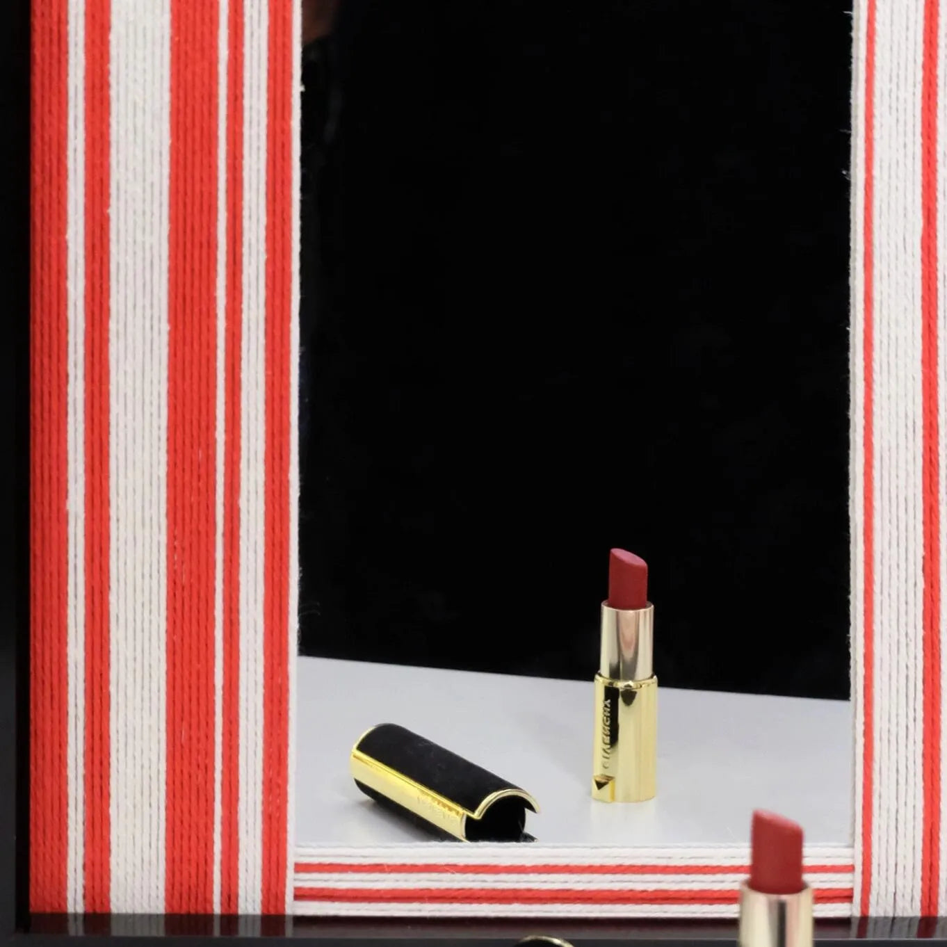 Close-up of Wave Tide mirror art capturing the smooth glass reflection and the crisp edge between the red wool stripe and black frame.
