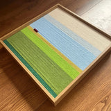 Angled overhead view of the soft cotton cord fiber artwork highlighting its horizontal yarn textures and landscape color blocking.