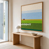 Whispering Fields blue, cream, yellow, and green yarn landscape wall art displayed above a wood console in a minimalist entryway.