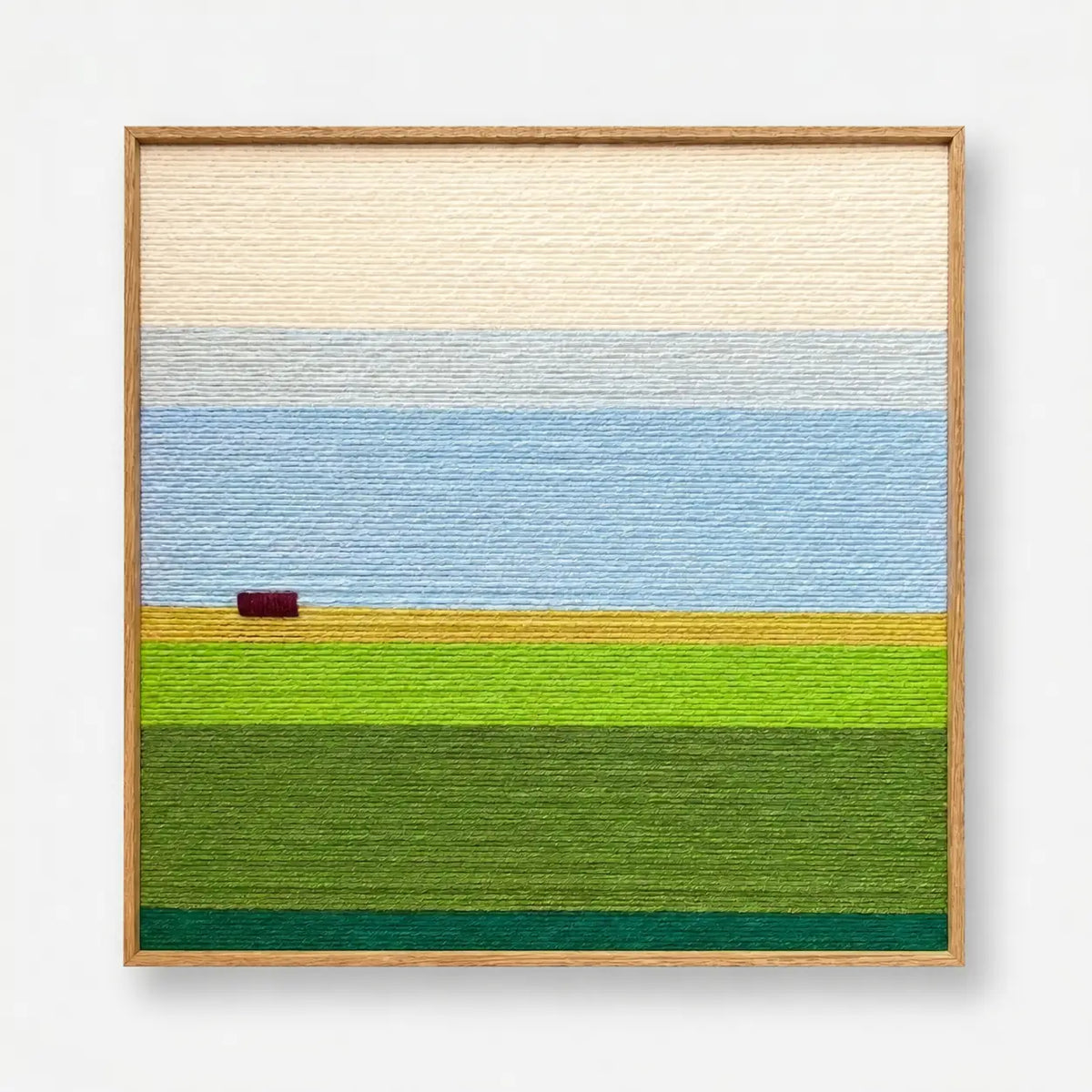 Full product view of the landscape soft cotton cord wall art framed neatly, showcasing cream sky and green fields.