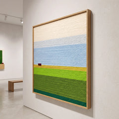 Side profile view of the framed wool wall art mounted on a gallery wall showing its depth and clean wooden frame.