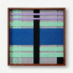 Frontal studio shot of the Winter Aurora hand-woven wool wall art featuring cobalt blue, mint green, and lavender patterns in a wooden frame against a clean white background.