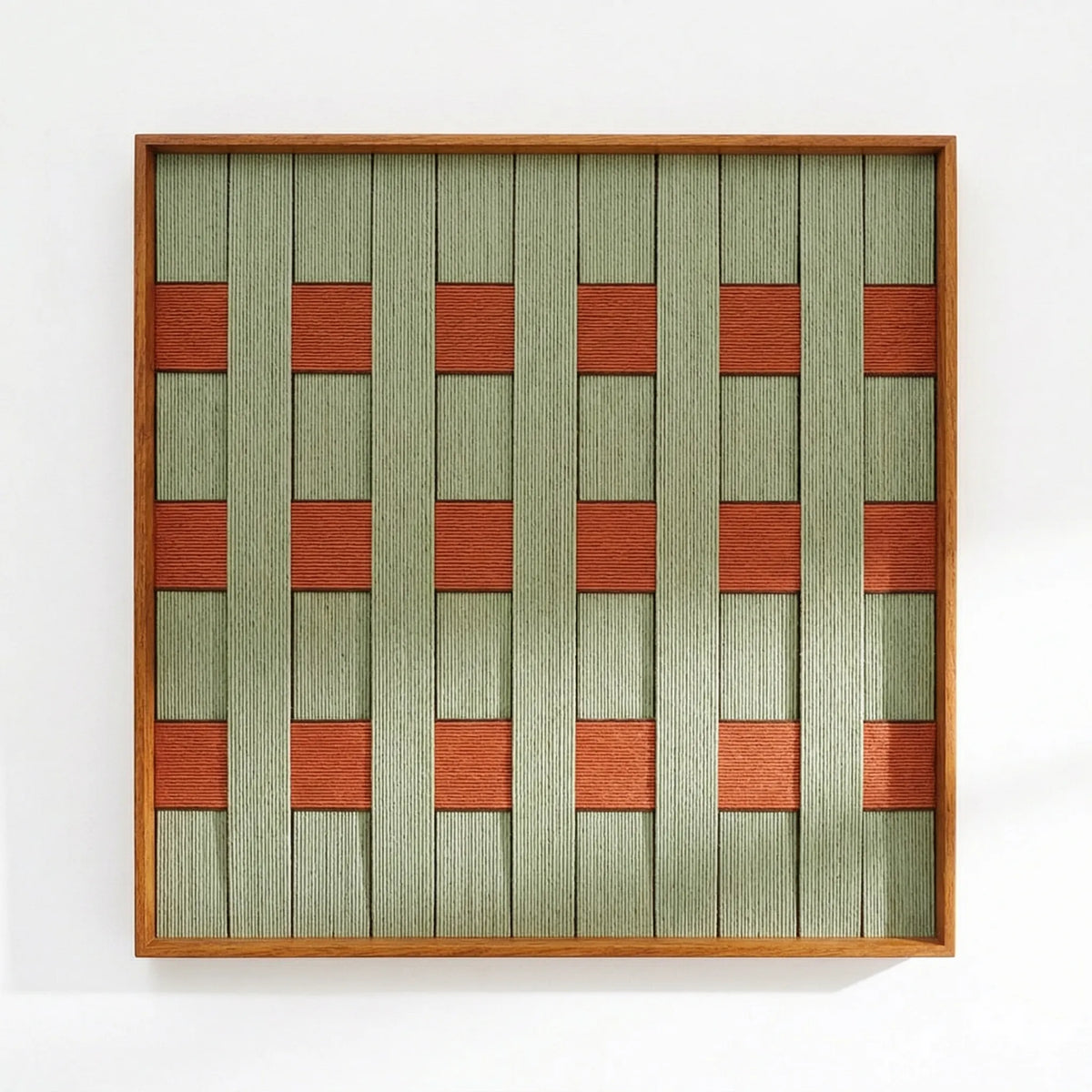 Direct front view of the hand-woven wool tapestry showing the intricate textured weave and geometric pattern in a light wood frame.